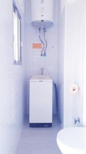 La salle de bains blanche est pourvue de toilettes et d'un lavabo. dans l'établissement Apartamento playa LLevant mejor zona Salou, à Salou