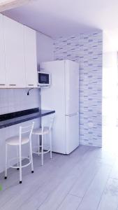 eine Küche mit weißen Schränken und einem weißen Kühlschrank in der Unterkunft Apartamento playa LLevant mejor zona Salou in Salou
