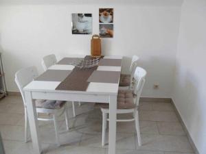 Neu Lüdershagen的住宿－Ferienwohnung Hinz，白色餐桌和白色椅子