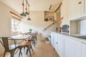 a kitchen with a long table and chairs at Heale Farm Cottage in Trentishoe