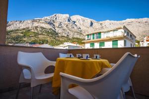 a table and chairs on a balcony with a mountain at Villa Nedo in Baška Voda