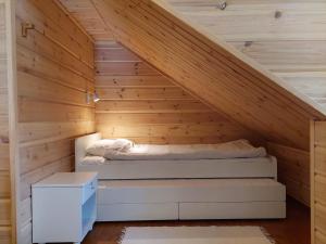 Bett in einem Zimmer mit Holzwänden in der Unterkunft Kantokelo B2 in Ylläsjärvi