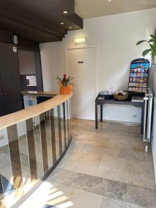 a hallway with a staircase and a table and a kitchen at Hotel de Vaart in Damme