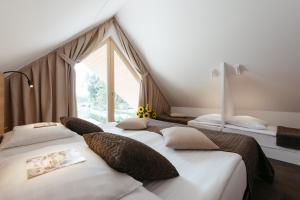 zwei Betten in einem Zimmer mit Fenster in der Unterkunft Hotel Ajda Depandance Prekmurska Vas - Terme 3000 - Sava Hotels & Resorts in Moravske-Toplice + 37 Fotos