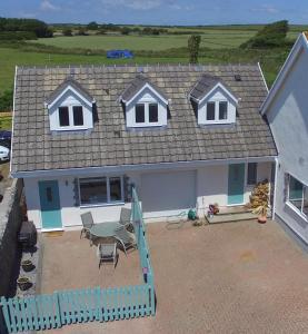 a house with a patio and a table and chairs at Sea dream lodge -coastal location/sea views/self-contained in Southerndown