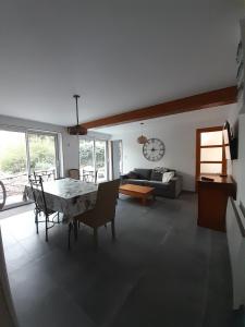 a living room with a table and chairs and a clock at Appartement sur jardin au calme à Pernes 1 chambre in Pernes