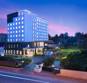 un hotel con un edificio iluminado al atardecer en HYCINTH Hotels, en Trivandrum