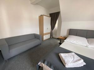 1 dormitorio con 1 cama y 1 sofá en Hostel, Gästehaus zum Molenfeuer, en Warnemünde