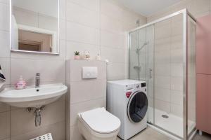 uma casa de banho branca com uma máquina de lavar roupa e um lavatório em Seaview apartment „Megan“ with sunny terrace em Kastav