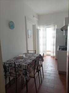 a table and chairs in a kitchen with a table and a window at Dimora Erminia in Polignano a Mare