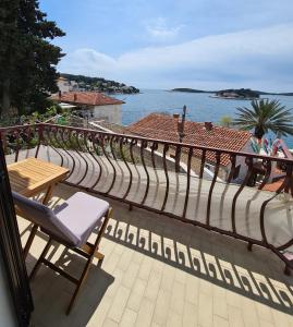 einen Balkon mit einem Tisch und Stühlen sowie Blick auf das Wasser in der Unterkunft Gordana Apartments in Hvar