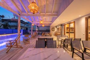 a patio with tables and chairs and a pool at Adonis Hotel in Pefkochori