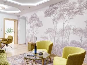 ein Wohnzimmer mit einem Wandbild von Bäumen in der Unterkunft Gasthof Hametner mit Innviertlerhof mit direktem Zugang zur Therme Mediterrana durch unseren Garten! in Bad Hall
