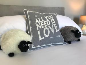 two stuffed sheep are sitting on a bed with a pillow at Inn Cardiff in Cardiff
