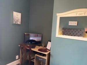 a desk with a monitor and a chair in a room at Inn Cardiff in Cardiff