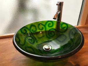 a green sink in a bathroom with a window at Inn Cardiff in Cardiff