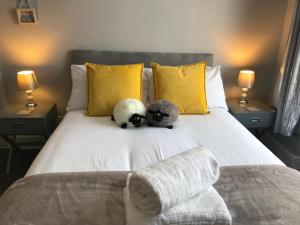 two stuffed animals sitting on a bed with two lamps at Inn Cardiff in Cardiff