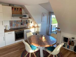 uma cozinha com mesa e cadeiras num quarto em Unser Haus am Deich - Wohnung Meerblick em Nordstrand