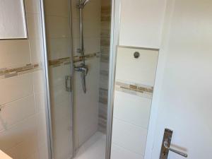 eine Dusche mit einer Glastür in einem Badezimmer in der Unterkunft Unser Haus am Deich Wohnung Meerblick in Nordstrand + 12 Fotos