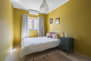 um quarto amarelo com uma cama e uma janela em Stylish 3 Bedroom Apartment - St. Julians - 5 mins from Balluta Bay em St. Julian's