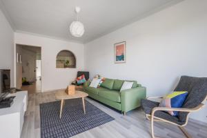 ein Wohnzimmer mit einem grünen Sofa und Stühlen in der Unterkunft Stylish 3 Bedroom Apartment - St. Julians - 5 mins from Balluta Bay in St Julian's