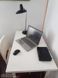 laptop i mysz na białym biurku w obiekcie Apartamento Portugalete w mieście Portugalete