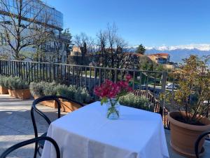 a table with a vase of flowers on a balcony at Hotel Tela & Mareli Winery in Telavi