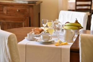 a table with a plate of food and glasses of wine at B&B Antica Corte in Cannole