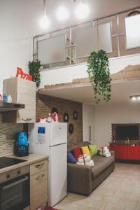eine Küche und ein Wohnzimmer mit einem Sofa in einem Zimmer in der Unterkunft Frizzi & Lazzi House in Neapel