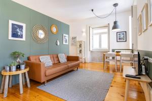 a living room with a brown couch and a table at Cozy Studio Apartment in Porto
