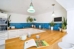 a kitchen with a wooden counter and blue tiles at Seashells - Bembridge in Bembridge