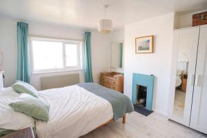 a bedroom with a bed and a fireplace at Seashells - Bembridge in Bembridge