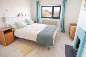 a bedroom with a large bed and a window at Seashells - Bembridge in Bembridge