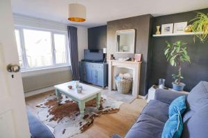 a living room with a blue couch and a table at Seashells - Bembridge in Bembridge