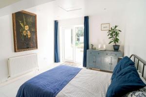 a bedroom with a blue bed and a window at Seashell, Bembridge in Bembridge