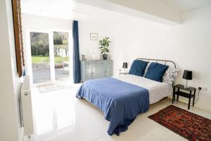 a bedroom with a bed and a sliding glass door at Seashells - Bembridge in Bembridge