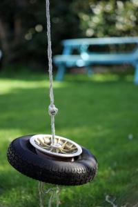 a tire swing with a bird feeder in a park at Seashells - Bembridge in Bembridge