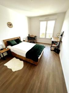 Neoresid Paris-Gagny في Gagny: غرفة نوم بسرير كبير وارضية خشبية