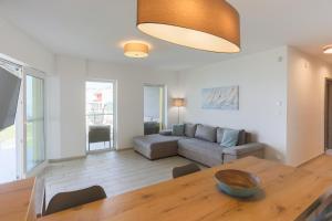 a living room with a table and a couch at Admiral Luxury III Apartman By BLTN in Siófok