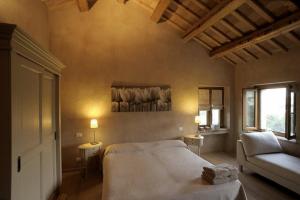 レカナーティにあるAgriturismo Il Gelso Anticoのベッドルーム(大型ベッド1台、ソファ付)