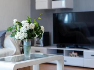 um vaso com flores brancas numa mesa numa sala de estar em Holiday home Mons Aureus em Gornje Sitno