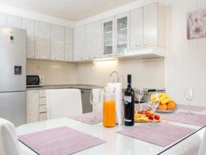 uma cozinha com uma mesa com dois copos de sumo de laranja em Holiday home Mons Aureus em Gornje Sitno