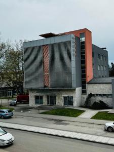 a building on a street with cars parked in front of it at Hotel Lukavac in Lukavac