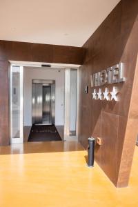 an empty elevator lobby with a sign on the wall at V Hotel in Ancona