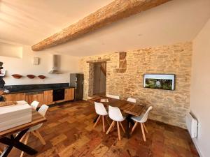 a kitchen and dining room with a wooden table and chairs at LE MOULIN DU VIVIER in Saint-Martin-Lalande
