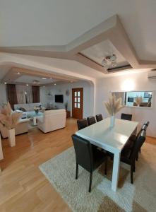 Villa KOD BUBE في ليوبوشكي: غرفة معيشة مع طاولة وكراسي بيضاء