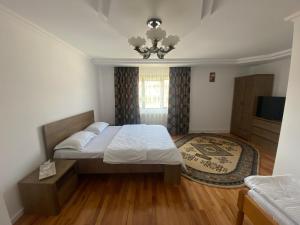 マナスティレア・フモルルイにあるCasa Laurのベッドルーム1室(ベッド1台、シャンデリア付)