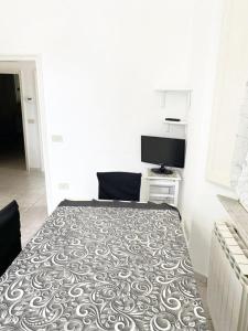 a bedroom with a bed and a television in it at Appartamento Mirellino a Marina di Cecina by Zoom In Earth in Marina di Cecina