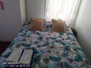 ein Bett mit zwei Kissen darauf in einem Schlafzimmer in der Unterkunft Apartamento Portugalete in Portugalete