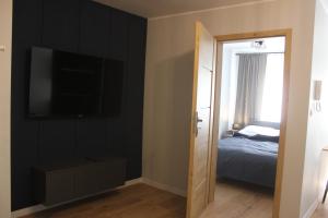 1 dormitorio con 1 cama y TV de pantalla plana en Apartamenty Przy Deptaku w Radomiu en Radom